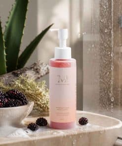 Flacon de Gel Nettoyant Visage Infusion Lumière Mimiastou-Glow-Skin présenté dans une ambiance naturelle avec des mûres et de l'eau.