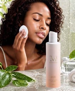 Un modèle appliquant la Lotion Pores Nets & Éclat Mimiastou-Glow-Skin avec un coton sur son visage.
