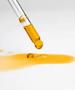 Goutte dorée et lumineuse de l'huile nutrition éclat Mimiastou-Glow-Skin sortant de la pipette.